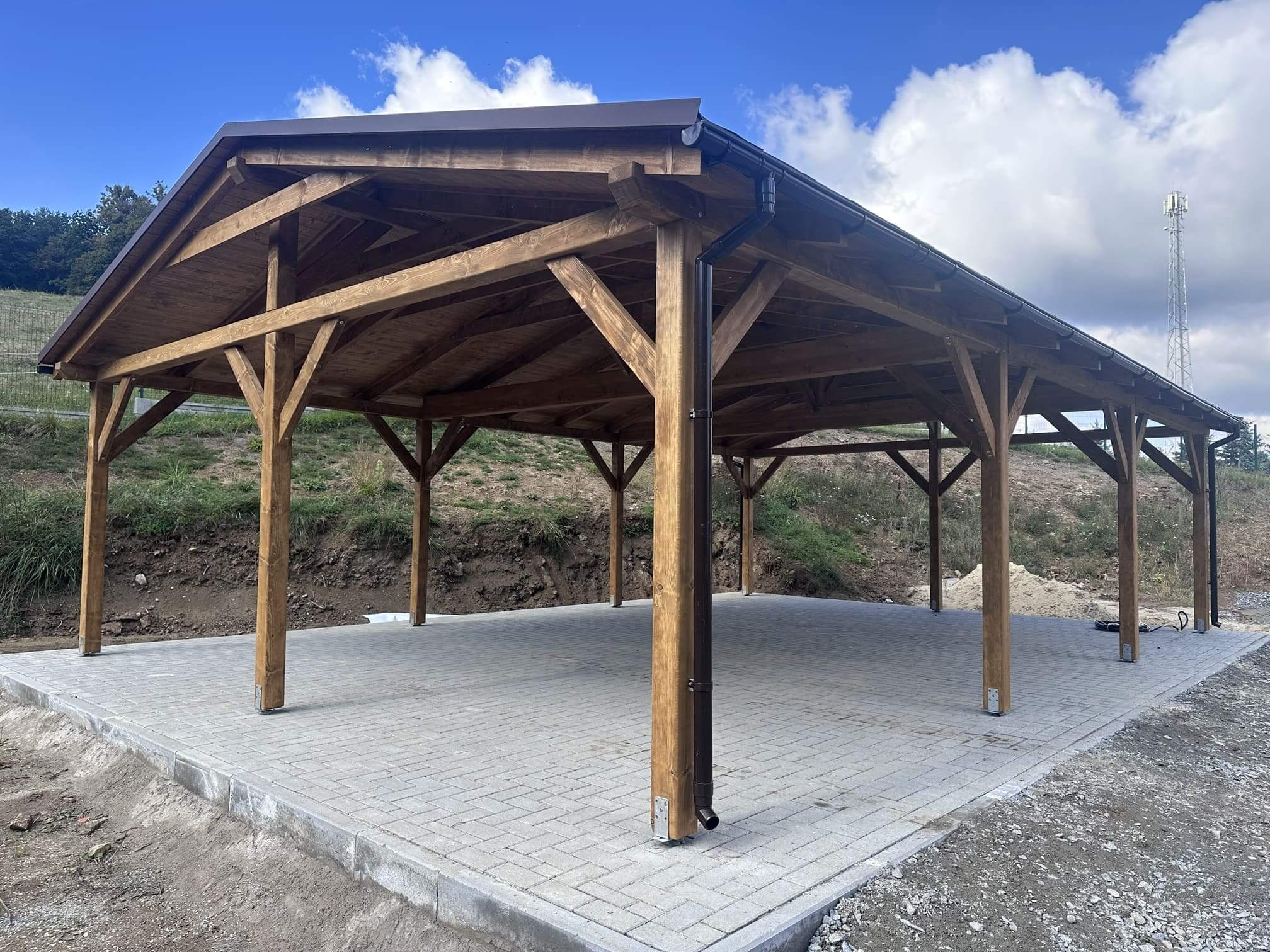 drewniana wiata na betonowej kostce brukowej pod niebieskim niebem
