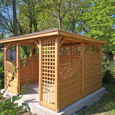 drewniana altana ogrodowa na betonowej podstawie wśród drzew